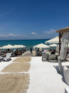 una spiaggia con sedie e ombrelloni e l'oceano di Sun & Stone House a Polykhrono