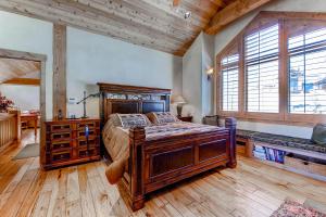 a bedroom with a large wooden bed and wooden floors at Three Peaks Mountain Lodge in Silverthorne