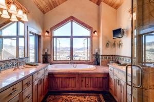 a large bathroom with a tub and a window at Three Peaks Mountain Lodge in Silverthorne +34 photos