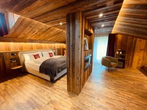 a bedroom with a bed in a room with wooden walls at Hotel Piccolo Tibet in Livigno
