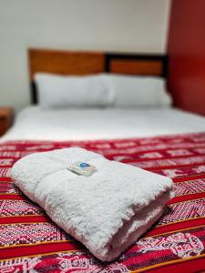 uma toalha branca sentada em cima de uma cama em HOSTAL QORI KANCHA'S INN em Cusco