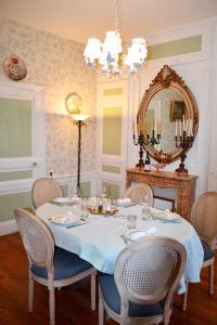 a dining room with a table with chairs and a mirror at Domaine de l'Hyères in Grandcourt