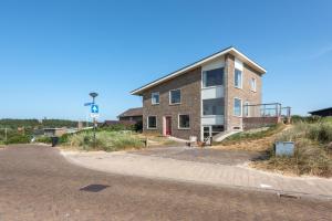duży ceglany budynek na poboczu drogi w obiekcie Zeezicht Villa Duin vlak bij strand en zee w mieście Bergen aan Zee