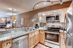 a kitchen with wooden cabinets and stainless steel appliances at Tenderfoot Lodge 2616 in Keystone