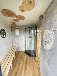 a room with a shower and a bench in it at RResort - nowe KLIMATYZOWANE domki z PODGRZEWANYM Basenem, Sauna, WiFi, parking w cenie! in Rewal