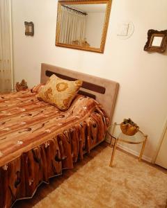 Schlafzimmer mit einem Bett, einem Spiegel und einem Tisch in der Unterkunft Apartman stan na dan Sarajevo in Sarajevo