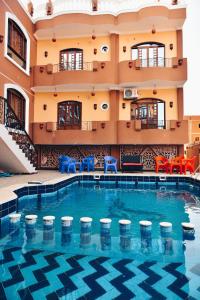 a large swimming pool in a hotel with blue chairs at Elwazan Hotel in Quseir