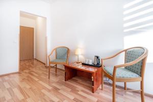 Habitación con 2 sillas y escritorio con lámpara. en Penzion LAGUNA, en Přimda