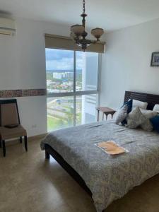 a bedroom with a bed and a large window at Playa Blanca Beach front Condo in Río Hato