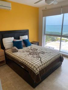 a bedroom with a large bed with a large window at Playa Blanca Beach front Condo in Río Hato