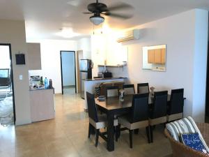 a dining room with a table and chairs and a kitchen at Playa Blanca Beach front Condo in Río Hato