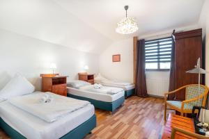 a bedroom with two beds and a table and a chair at Penzion LAGUNA in Přimda