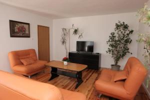 salon z 2 pomarańczowymi krzesłami i stolikiem kawowym w obiekcie Blue Sky Trogir w mieście Plano