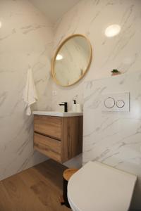 W łazience znajduje się umywalka i lustro. w obiekcie Blue Sky Trogir w mieście Plano