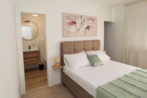 sypialnia z łóżkiem oraz łazienka z lustrem w obiekcie Blue Sky Trogir w mieście Plano