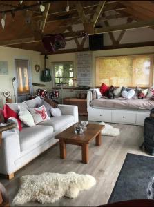 a living room with two couches and a coffee table at Angies Den - quirky cabin with hot tub & views in Llanasa