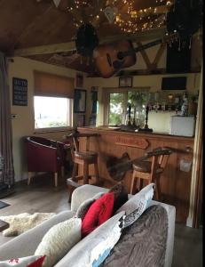 a living room with two couches and a bar at Angies Den - quirky cabin with hot tub & views in Llanasa