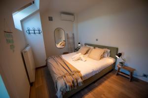 een slaapkamer met een groot bed met een spiegel bij Boutique Hotel Het Zoete Zijn in Borgloon +63 foto's