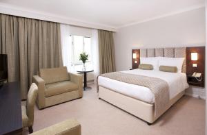 a hotel room with a large bed and two lamps at Sudbury House in Faringdon