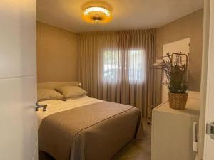 Schlafzimmer mit einem Bett und einem Fenster in der Unterkunft La casita blanca - Bungalow 20m from the sea! in Miami Platja