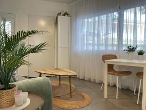 ein Wohnzimmer mit einem Tisch, einem Tisch und Stühlen in der Unterkunft La casita blanca - Bungalow 20m from the sea! in Miami Platja