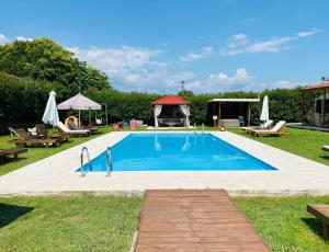 a swimming pool with chairs and a gazebo at THE MANSION OF DIONISOS AND DIMITRAS in Linariá