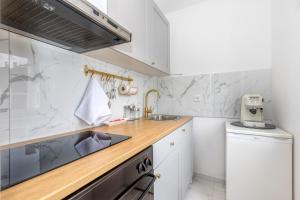 a white kitchen with a sink and a dishwasher at Mountain View Apartment Lika**** in Gospić