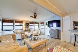 a living room with white furniture and a flat screen tv at Waterfront Home with Dock in South Grand Lake! in Vinita