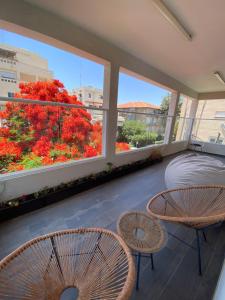 un balcone con un letto, 2 sedie e una finestra di Boutique Penthouse by Weizmann - פנטהאוס בוטיק a Rechovot