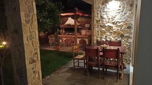 una mesa de comedor y sillas en un patio trasero por la noche en Sea Soul, en Artemida