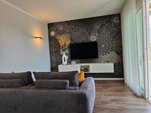 ein Wohnzimmer mit einem Sofa und einem TV an der Wand in der Unterkunft San Giorgio Design Home in Colà di Lazise
