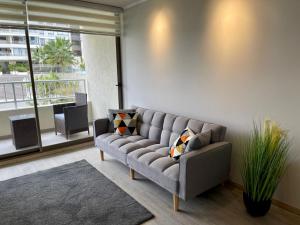 a living room with a couch and a large window at Departamento Nuevo!!! Sector Residencial Ciudad Iquique in Iquique
