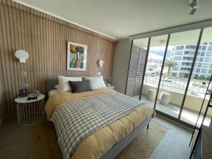 a bedroom with a large bed and a large window at Departamento Nuevo!!! Sector Residencial Ciudad Iquique in Iquique