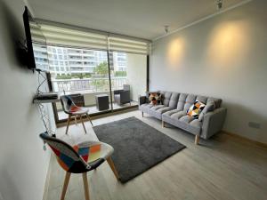 a living room with a couch and a chair at Departamento Nuevo!!! Sector Residencial Ciudad Iquique in Iquique