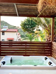 a bath tub in front of a large window at Palma Deluxe House in Sarti