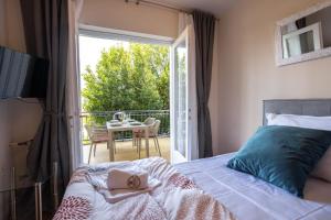 a bedroom with a bed and a balcony with a table at Apartments Lonzor I in Selce