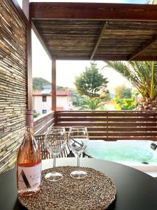 una botella de vino y dos copas de vino en una mesa en Palma Deluxe House, en Sarti