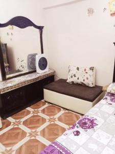 Habitación pequeña con cama, espejo y espejo. en شقة مفروشة 5 سراير في كامب شيزار, 