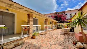 a courtyard of a house with plants and a patio at Nine Muses Apartments in Kavos