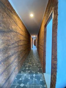um corredor com piso em azulejo e uma parede em Anugrah Hotel em Teluknarat