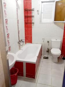 a bathroom with a bath tub and a toilet at شقة مفروشة 5 سراير في كامب شيزار 