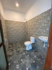 uma casa de banho com um WC e um lavatório em Anugrah Hotel em Teluknarat