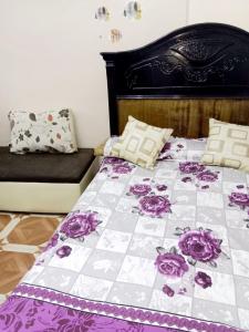 a bed with a purple and white quilt on it at Happy Vacations 