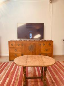 a wooden entertainment center with a flat screen tv on top at Leicester city centre flat in Leicester