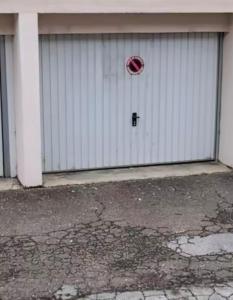 un garaje blanco con una puerta con una señal de stop. en LE 46 : Superbe appartement jacuzzi, en Besançon