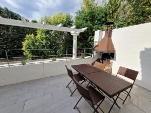 a patio with a table and chairs and a grill at maison PING ,en face des arènes in Béziers