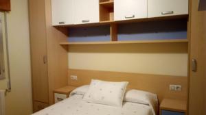 a small room with a bed and some cabinets at Casa de verano in O Grove