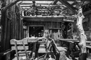 ein schwarz-weißes Foto einer Holzhütte mit einem Tisch und Stühlen in der Unterkunft Vila Rustik Straja in Lupeni