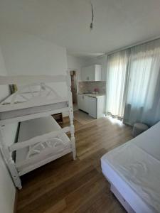 a bedroom with two bunk beds and a kitchen at Apartman Hana in Donji Štoj