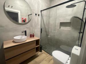 a bathroom with a shower and a sink and a mirror at APARTAMENTOS SOL Y LUNA in La Línea de la Concepción